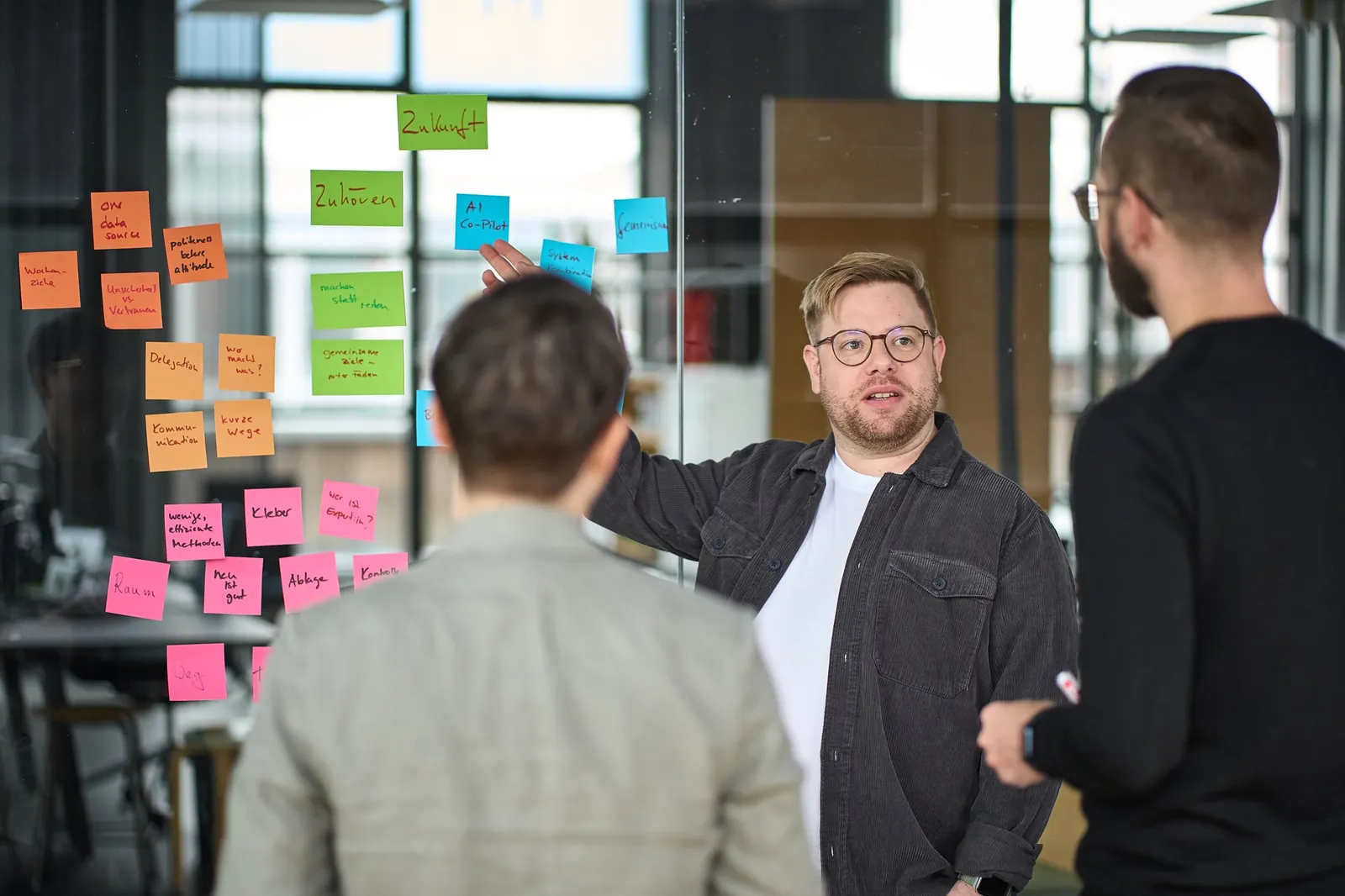 Workshop-Team entwickelt Vision, Mission und Strategie gemeinsam an einem Whiteboard mit Post-its.