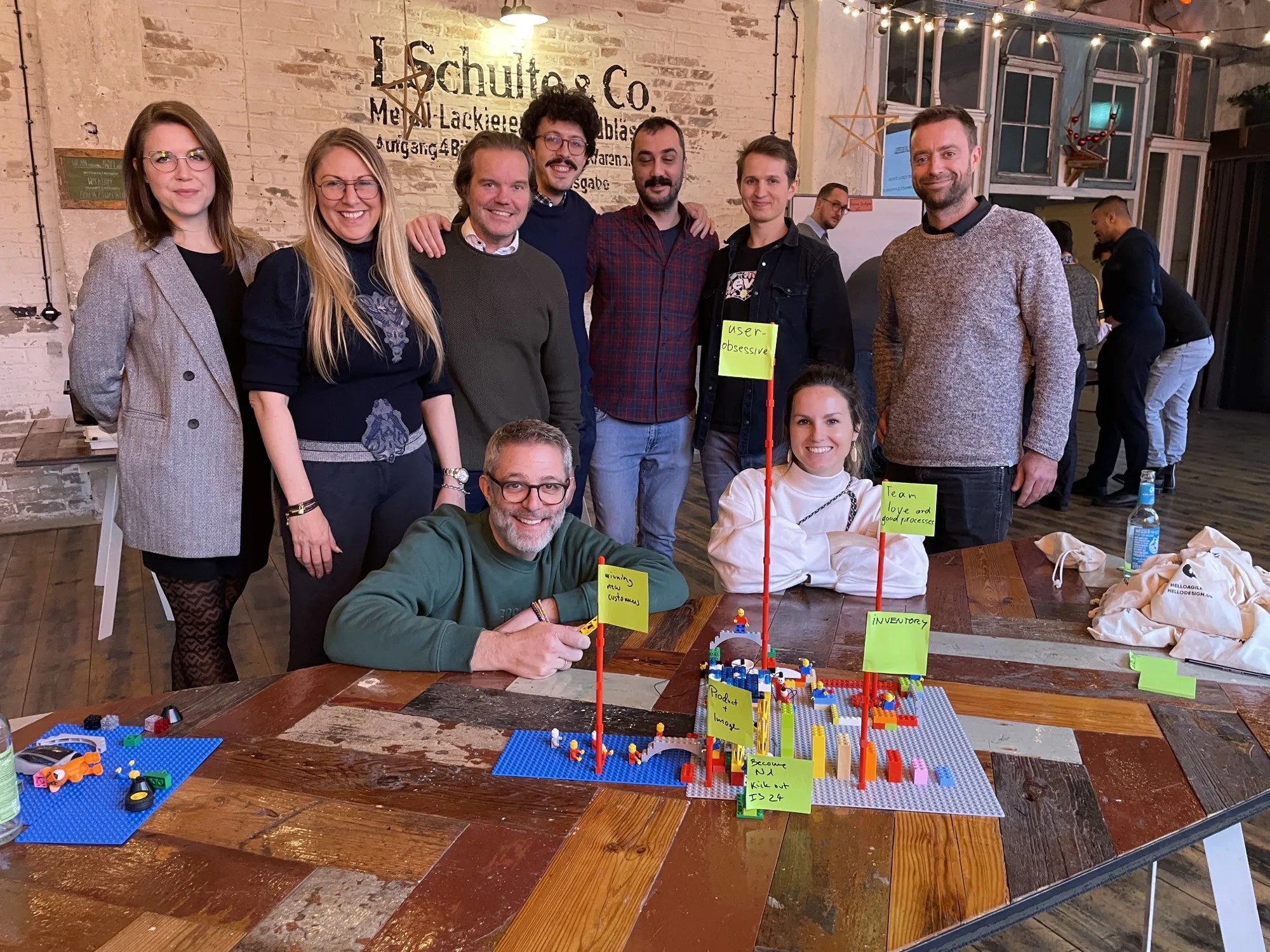 Team lacht hinter einer LEGO-Landschaft