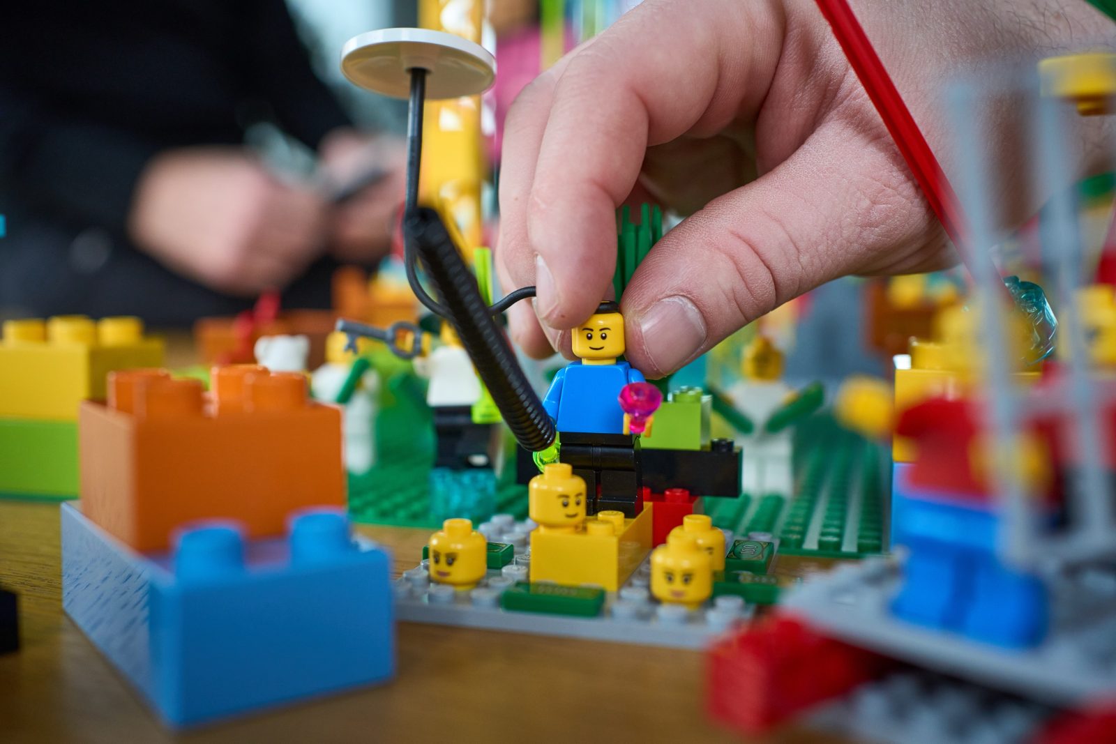 Hand stellt eine LEGO-Figur in ein Modell