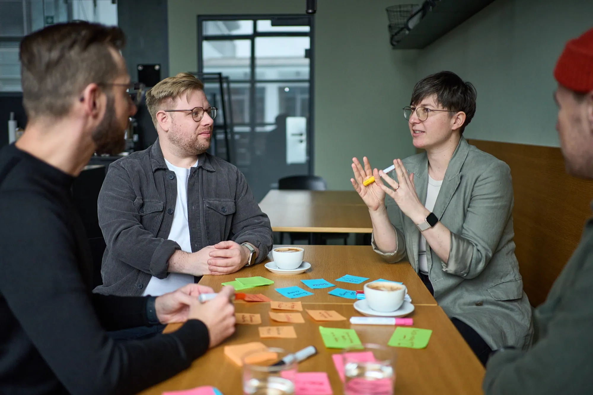 Teilnehmerin erklärt der Gruppe am Tisch