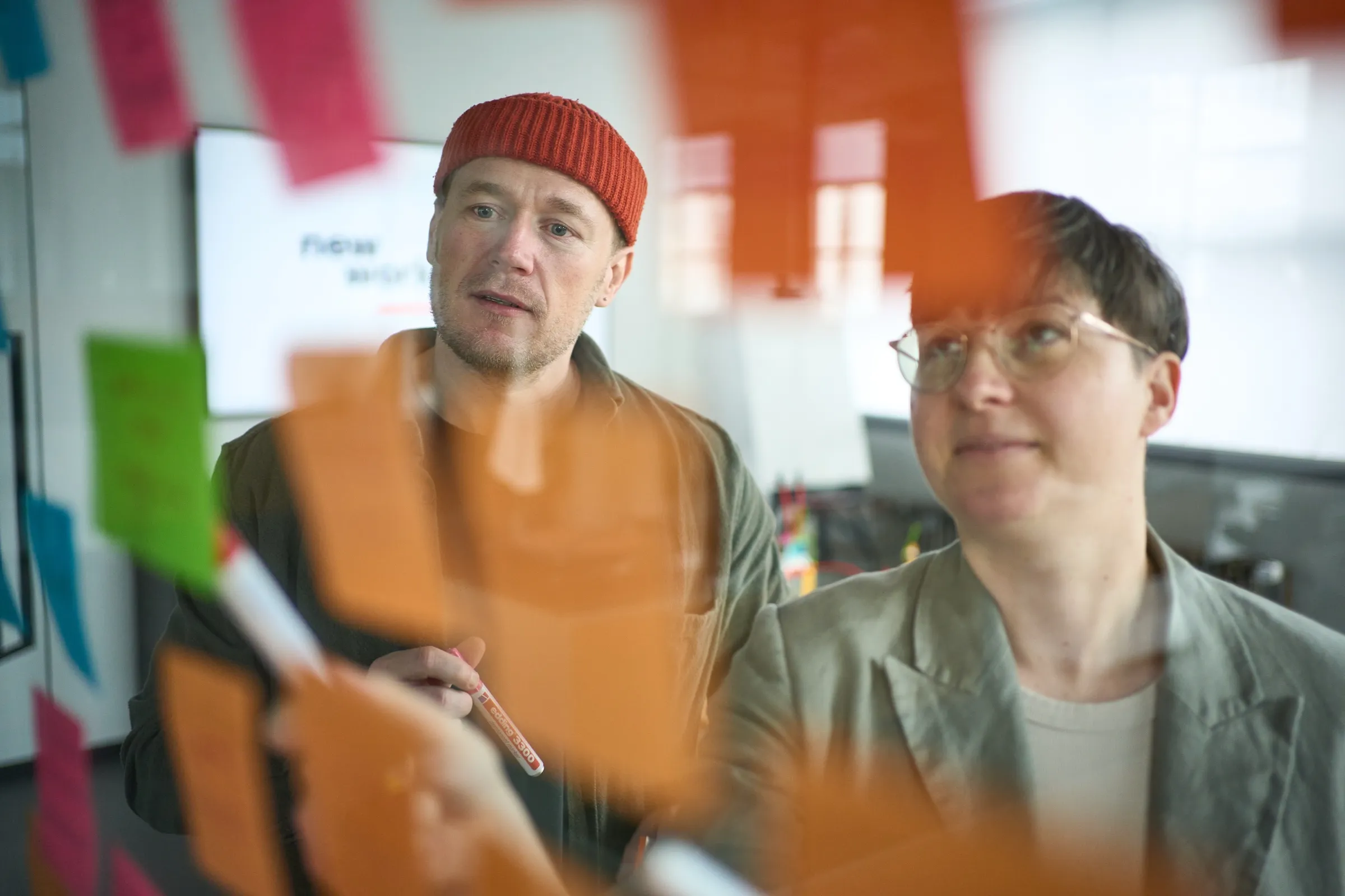 Zwei Personen diskutieren hinter Haftnotizen