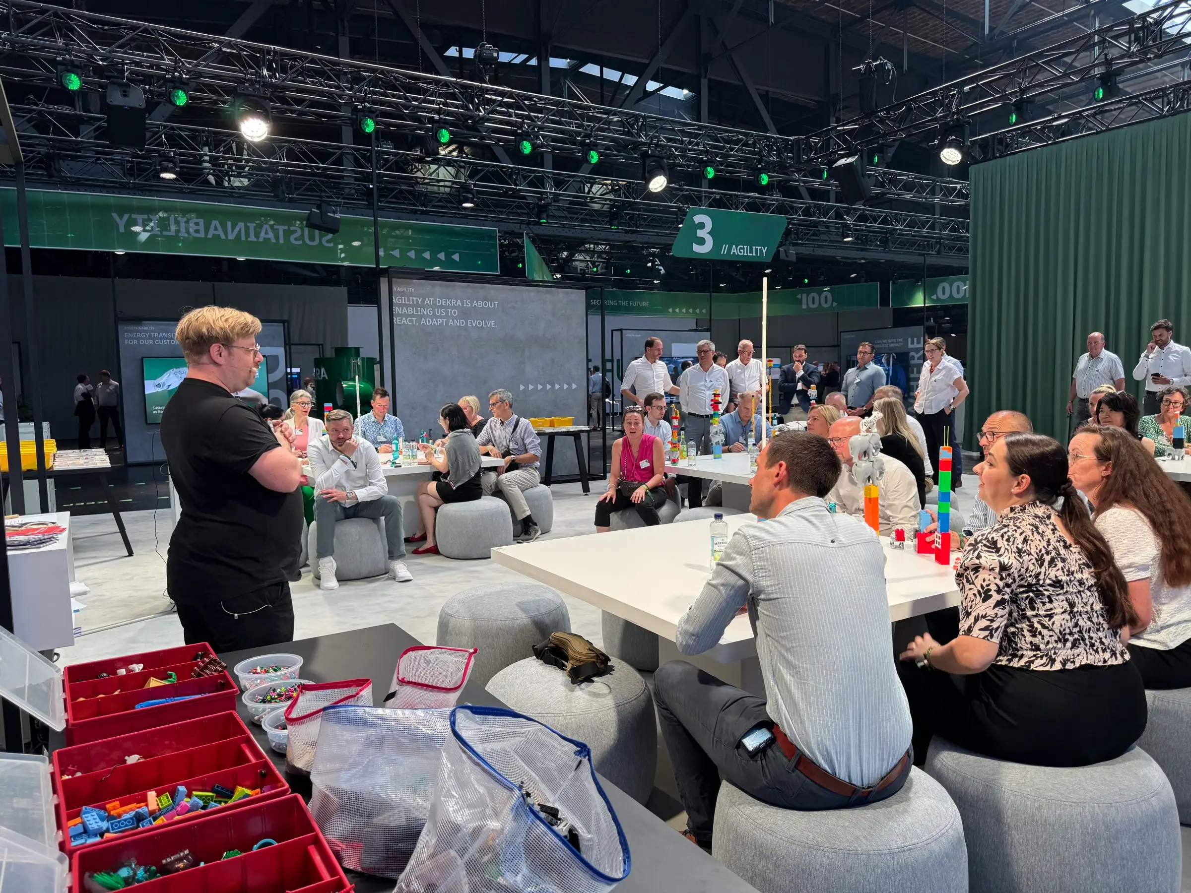 Sebastian Wolf moderiert ein Firmenevent mit vielen Tischgruppen