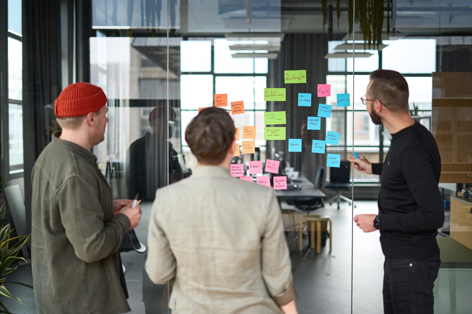 Kleingruppe arbeitet an einer Wand mit Haftnotizen