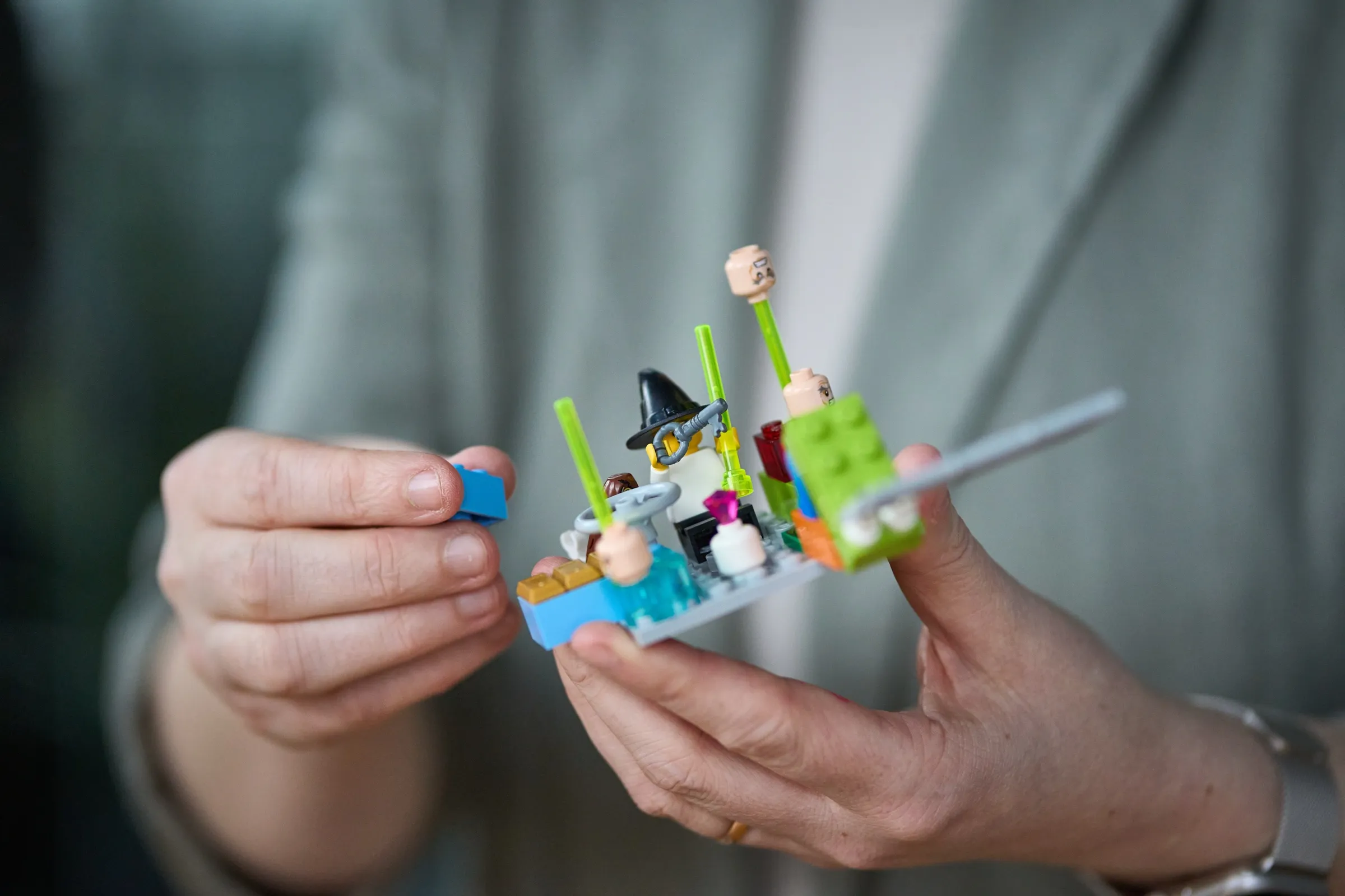Hände halten ein kleines LEGO-Modell